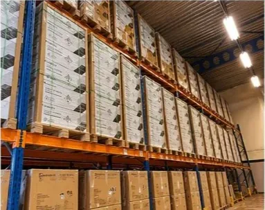 Rząd regałów paletowych z towarem Growatt w magazynie PVGroup.pl